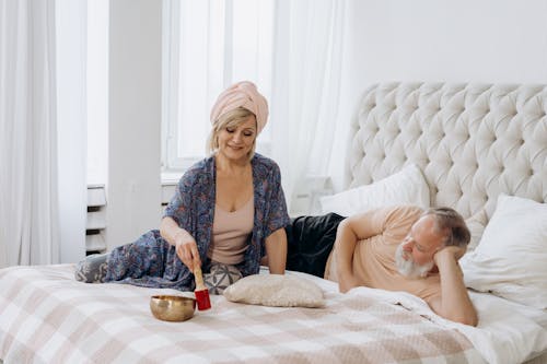 Free A Couple in Bed with Golden Bowl Stock Photo