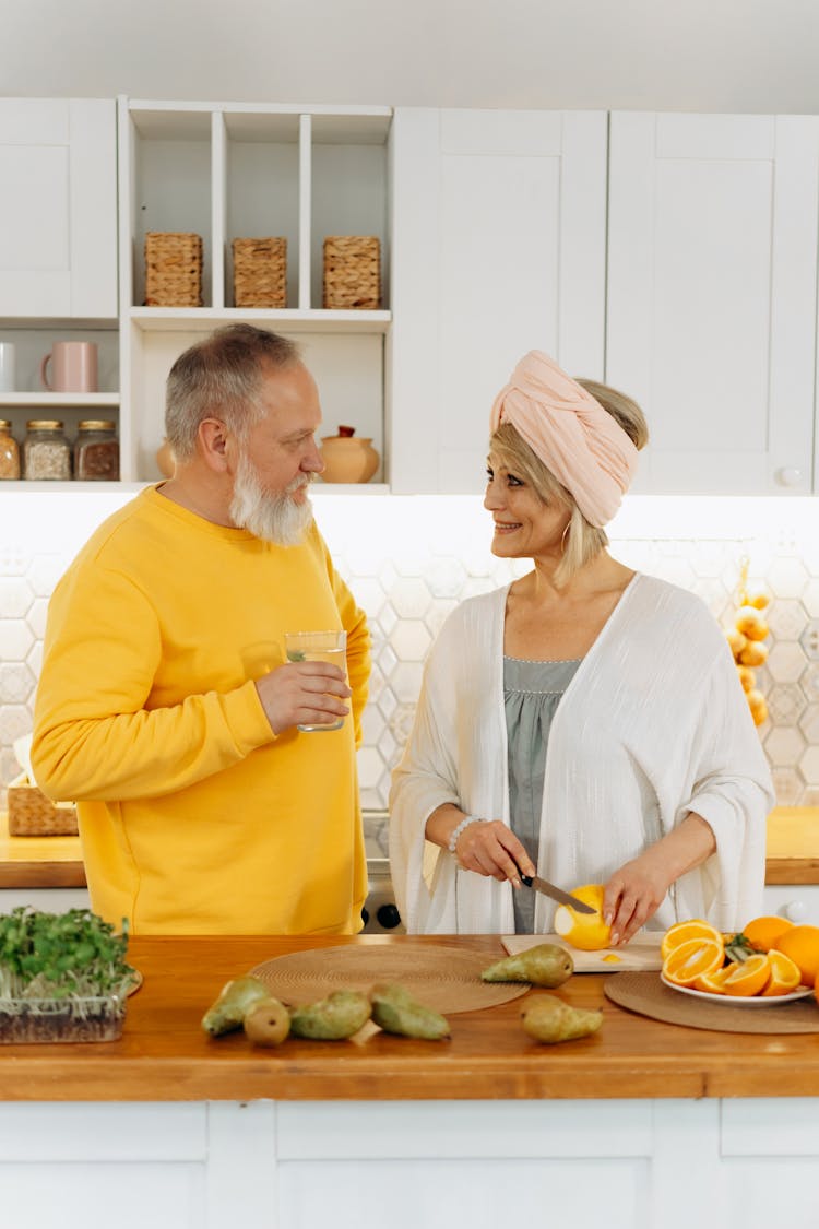 An Elderly Man Looking At His Wife While Holding A Glass Of Water