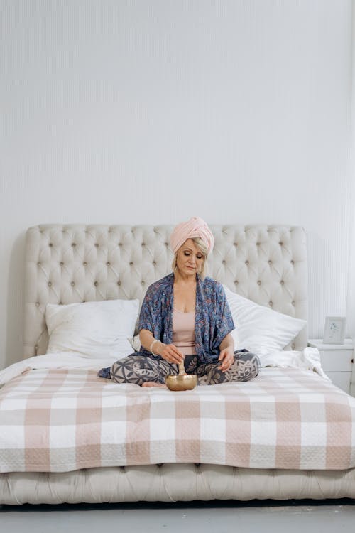 Free Woman with Headdress Sitting on Bed Stock Photo