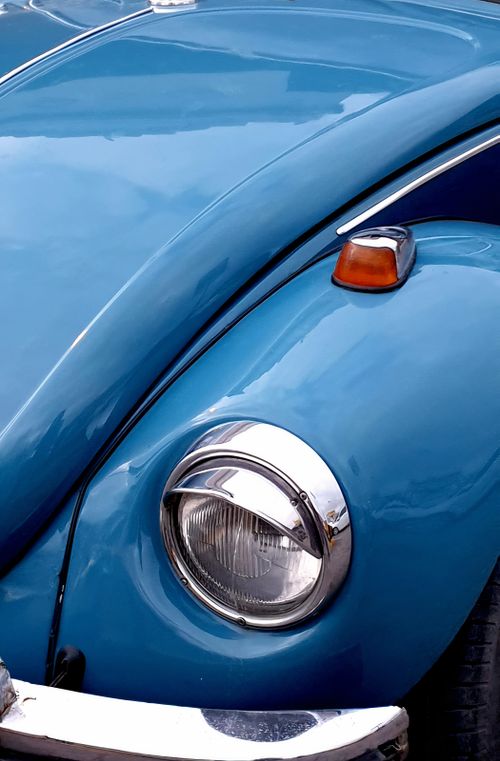 Free Detailed shot of a classic blue vintage Volkswagen Beetle car hood with headlight. Stock Photo