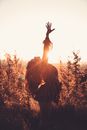 Graceful woman with raised arm in long grass