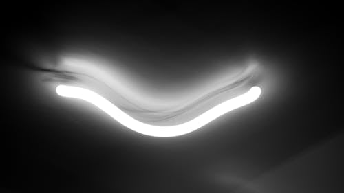 Black and white of glowing white light in long exposure in dark background