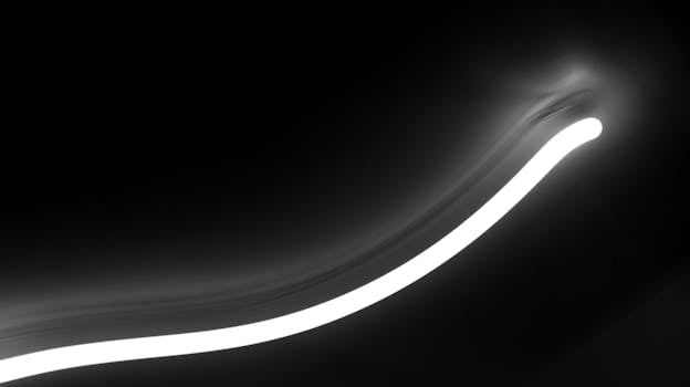 Dynamic black and white abstract image with a glowing light curve, full of mystery and movement.