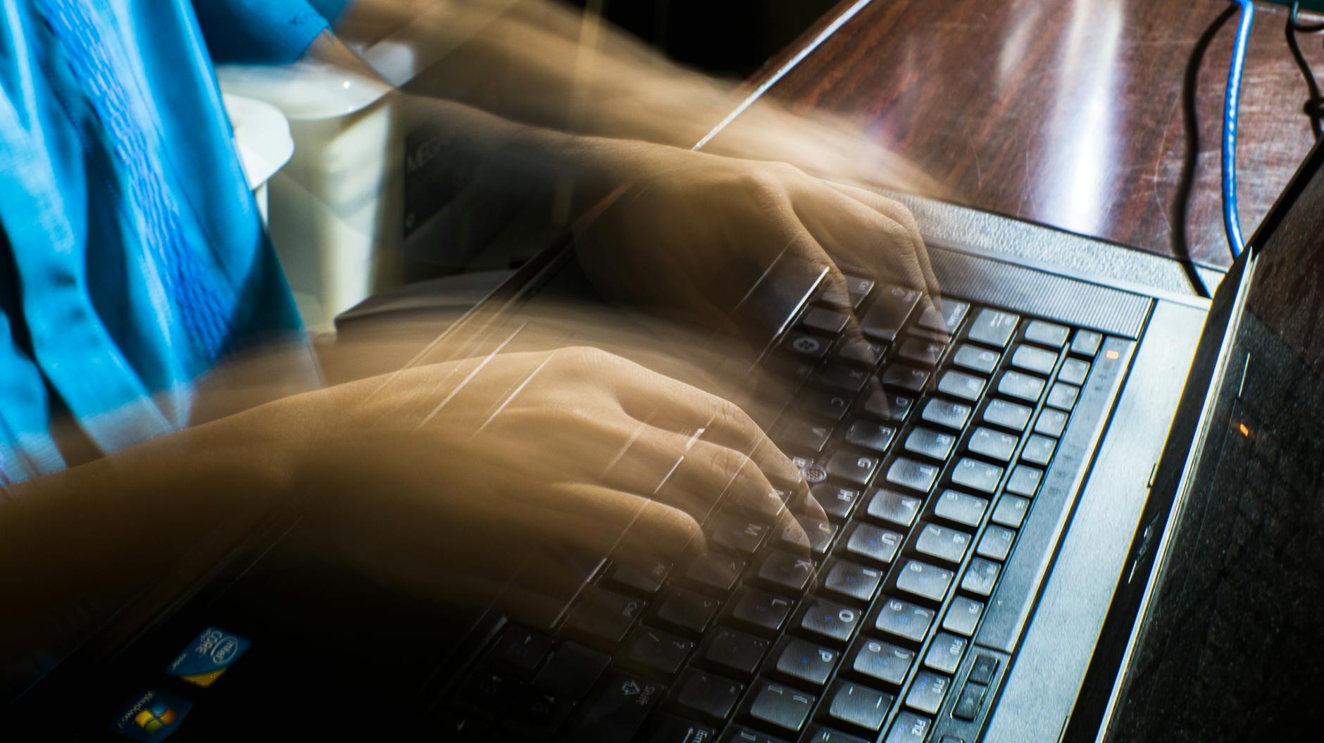 How AI is Streamlining Operations in the Energy Sector: Key Insights and Trends 2 Blurred hands typing fast on a laptop, emphasizing speed and technology.