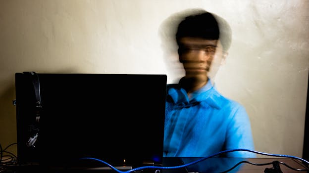 A man with blurred motion is working at his computer, conveying a sense of speed and concentration.