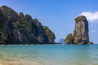 Green and Brown Rock Formation on Sea Water Under Blue Sky