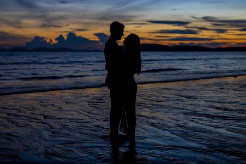 Couple Hugging on Sea Shore at Sunset