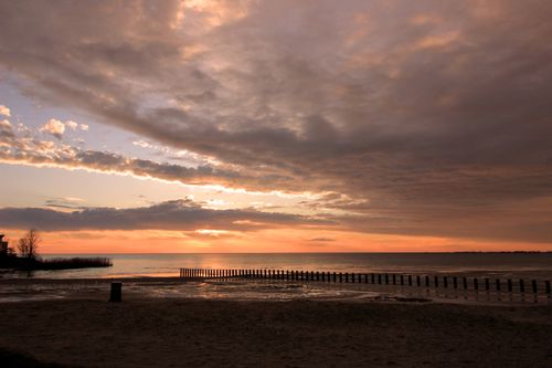 Free Tranquil beach view at sunset in Makkum, Netherlands with vibrant clouds and calm waters. Stock Photo