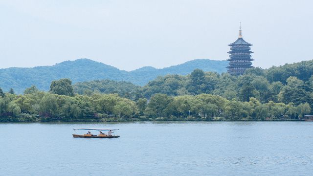 Peaceful scene featuring a boat on West Lake with Leifeng Pagoda in Hangzhou, China. — lounges at Hangzhou Airport