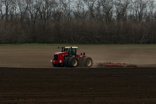 Red Tractor Plowing the Field