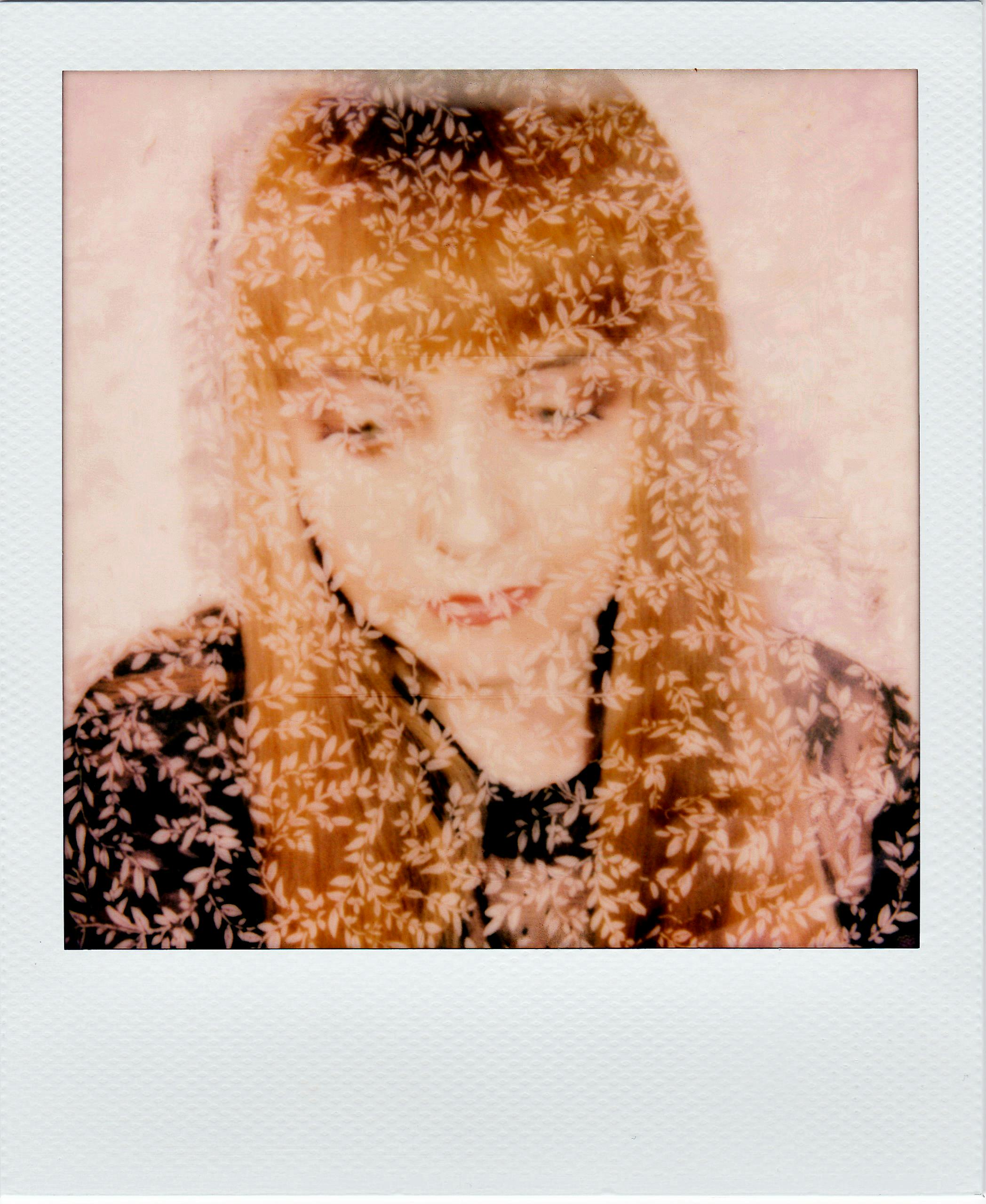 A creative portrait of a woman with a floral overlay, evoking a dreamy atmosphere.