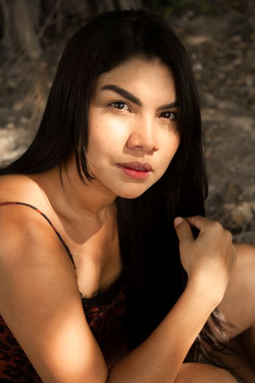 Free Capture of a woman in natural light with a serene expression outdoors. Stock Photo