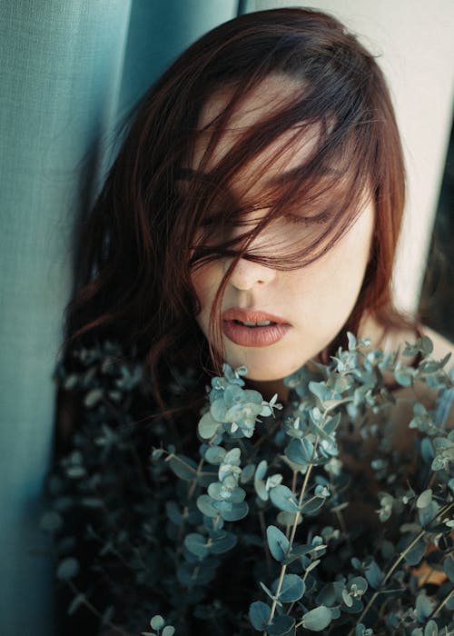 Dreamy woman with bunch of plants