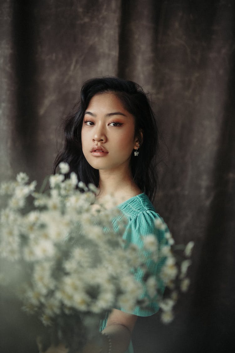 Young Ethnic Woman Standing With Bouquet Of Flowers