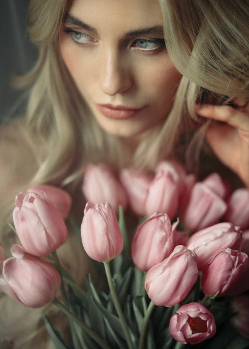 Young woman with bouquet of fresh blooming tulips