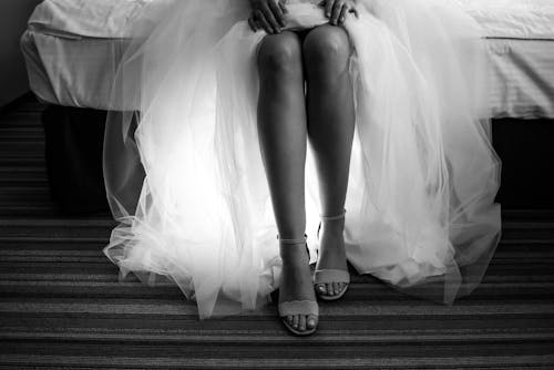 Free A Woman Wearing a Dress and Sitting on a Bed Stock Photo