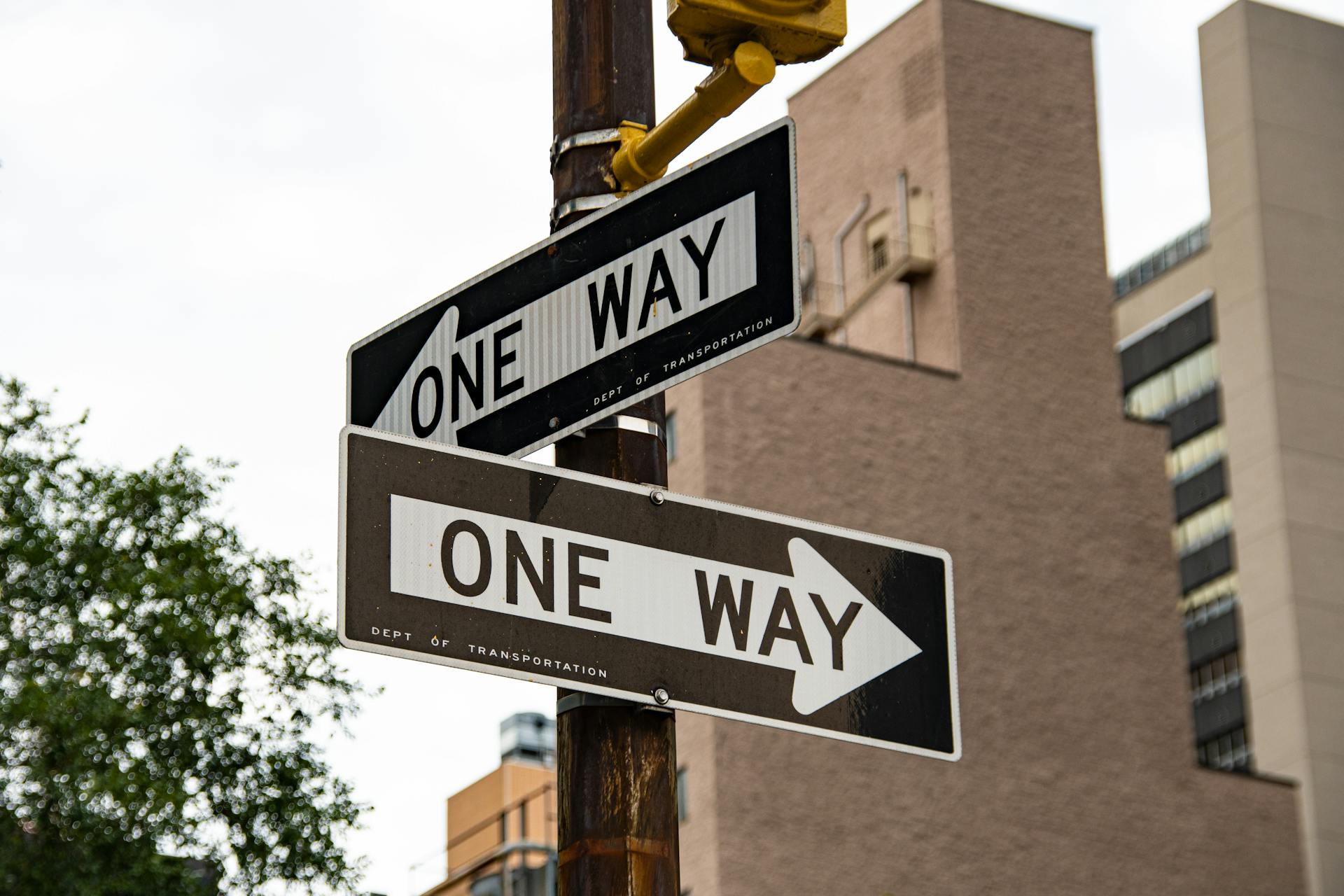 Close-up of one way street signs in urban New York City setting.