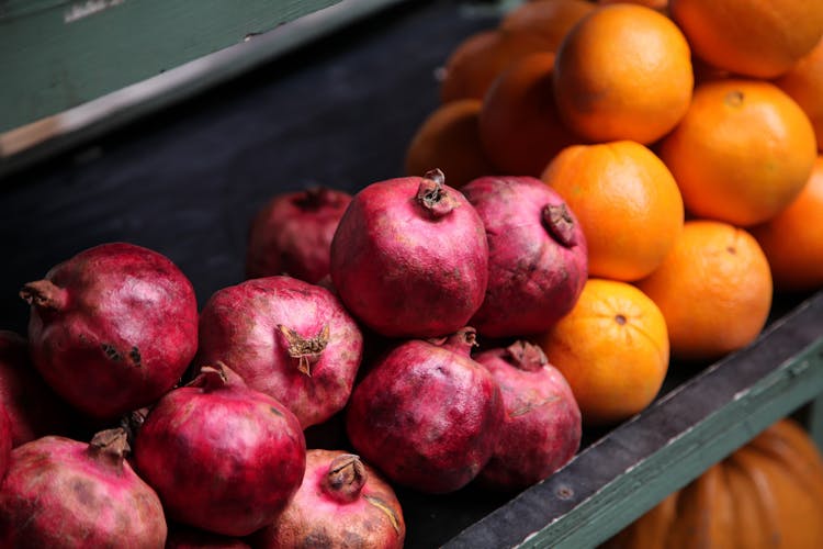 Pink Pomegranates And Oranges On A Market Stall