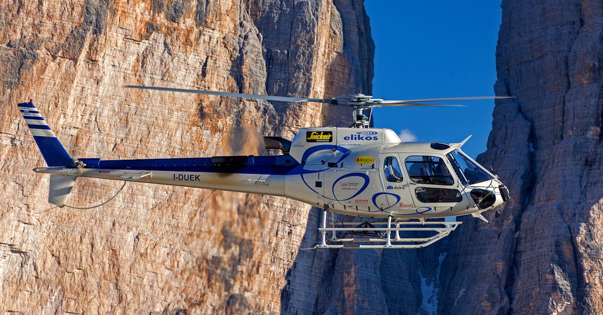 Selective Photograph of White Helicopter Near Brown Mountains