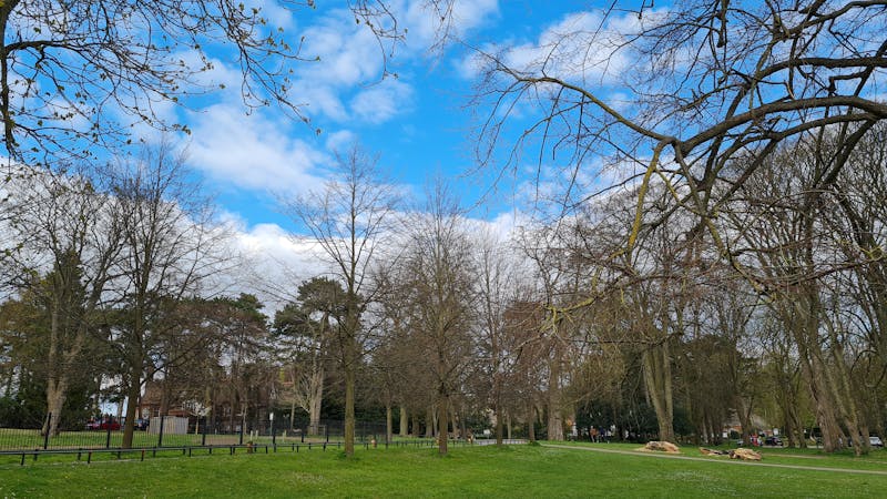 Mâini meșteșugărești tăind o bucată de sticlă colorată cu un instrument specializat