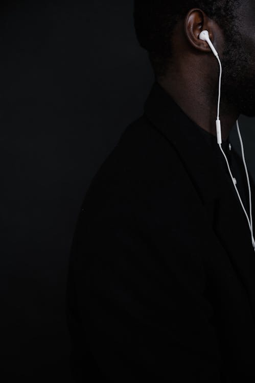 Crop black man with white earphones listening to music · Free Stock Photo