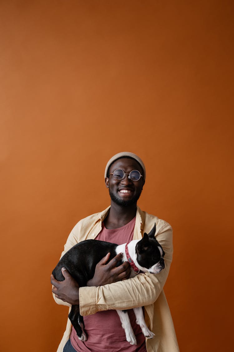 Cheerful Black Man Holding Dog