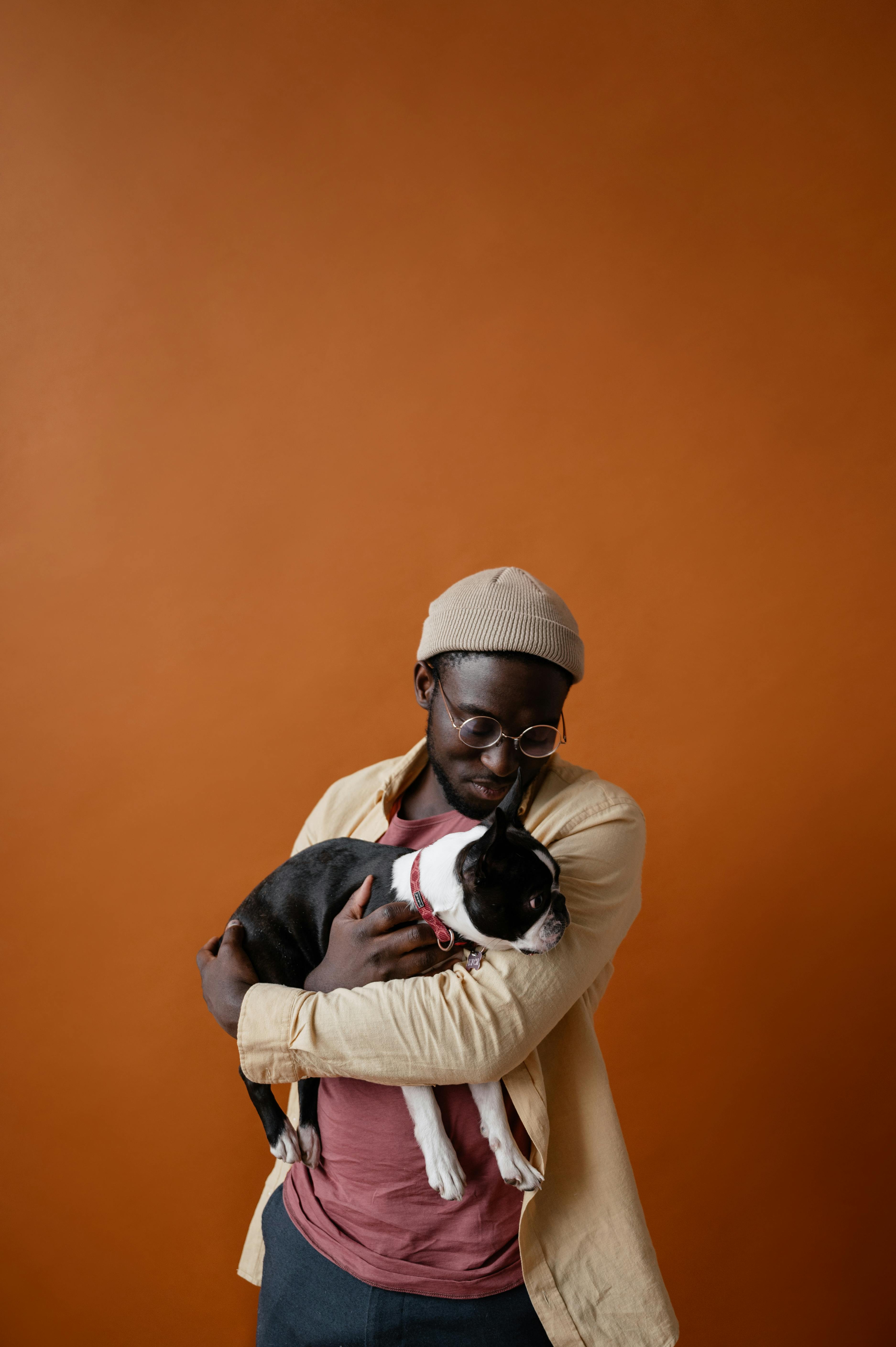 black man holding dog in hands in studio