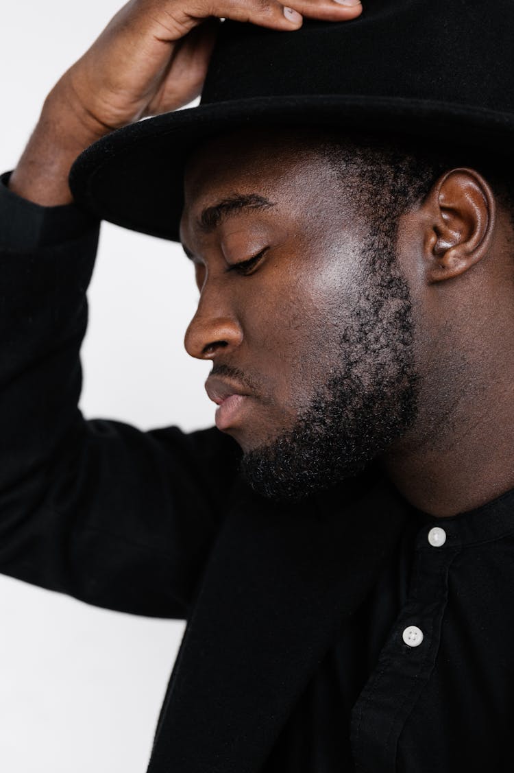 Stylish Black Man In Black Suit And Hat Looking Down