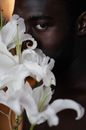 Black man holding white flowers