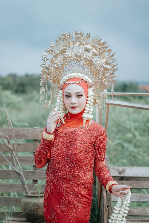 Free A woman in traditional attire with a detailed headdress stands outdoors, celebrating cultural heritage. Stock Photo