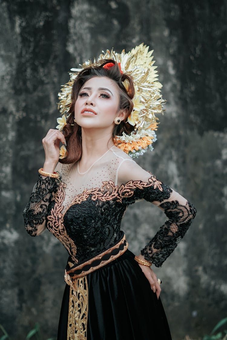 Woman Posing In A Black Embroidered Dress And Golden Decorative Plume