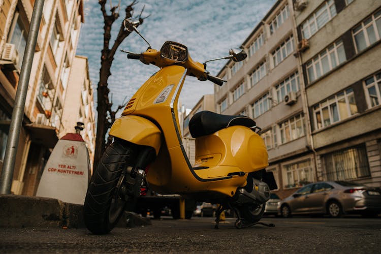 A Yellow Motor Scooter Parked On The Road