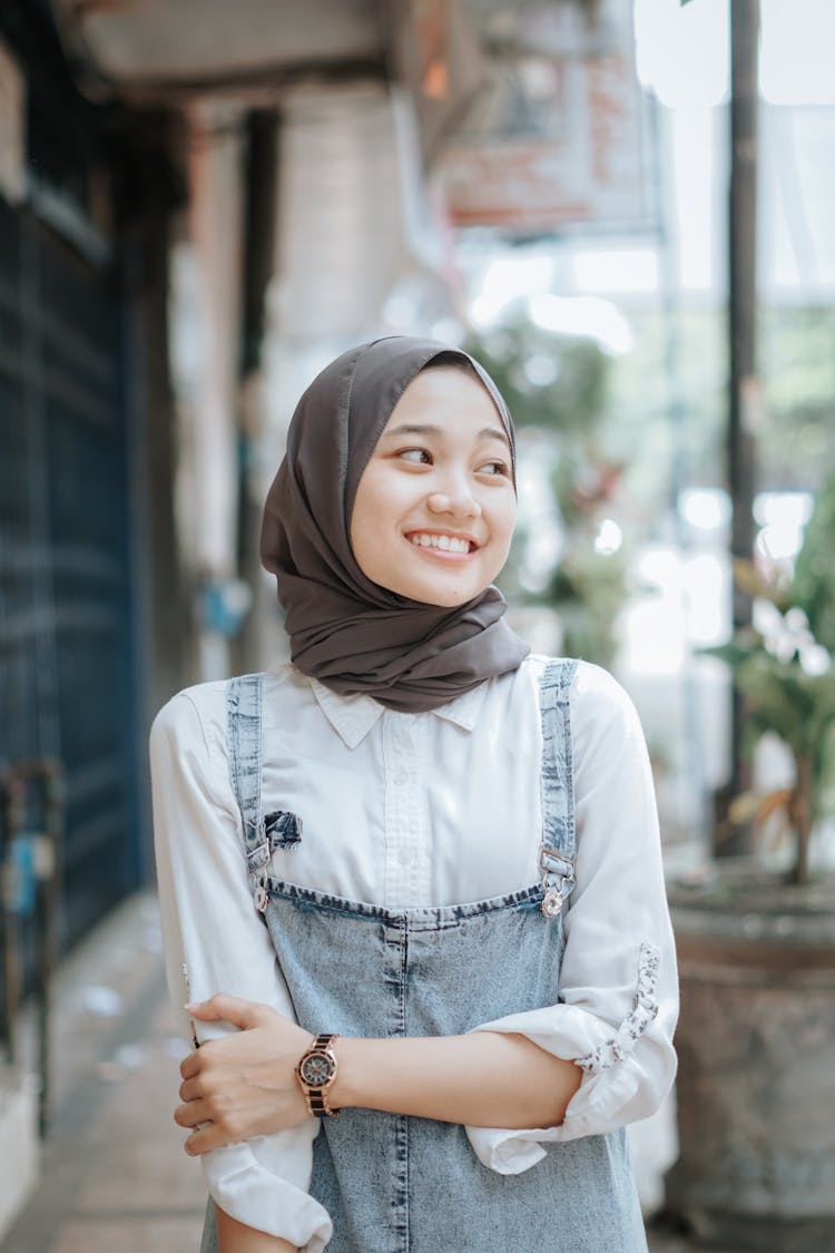 Portrait Of A Shy Girl In A Beige Headscarf And Jeans Dungarees