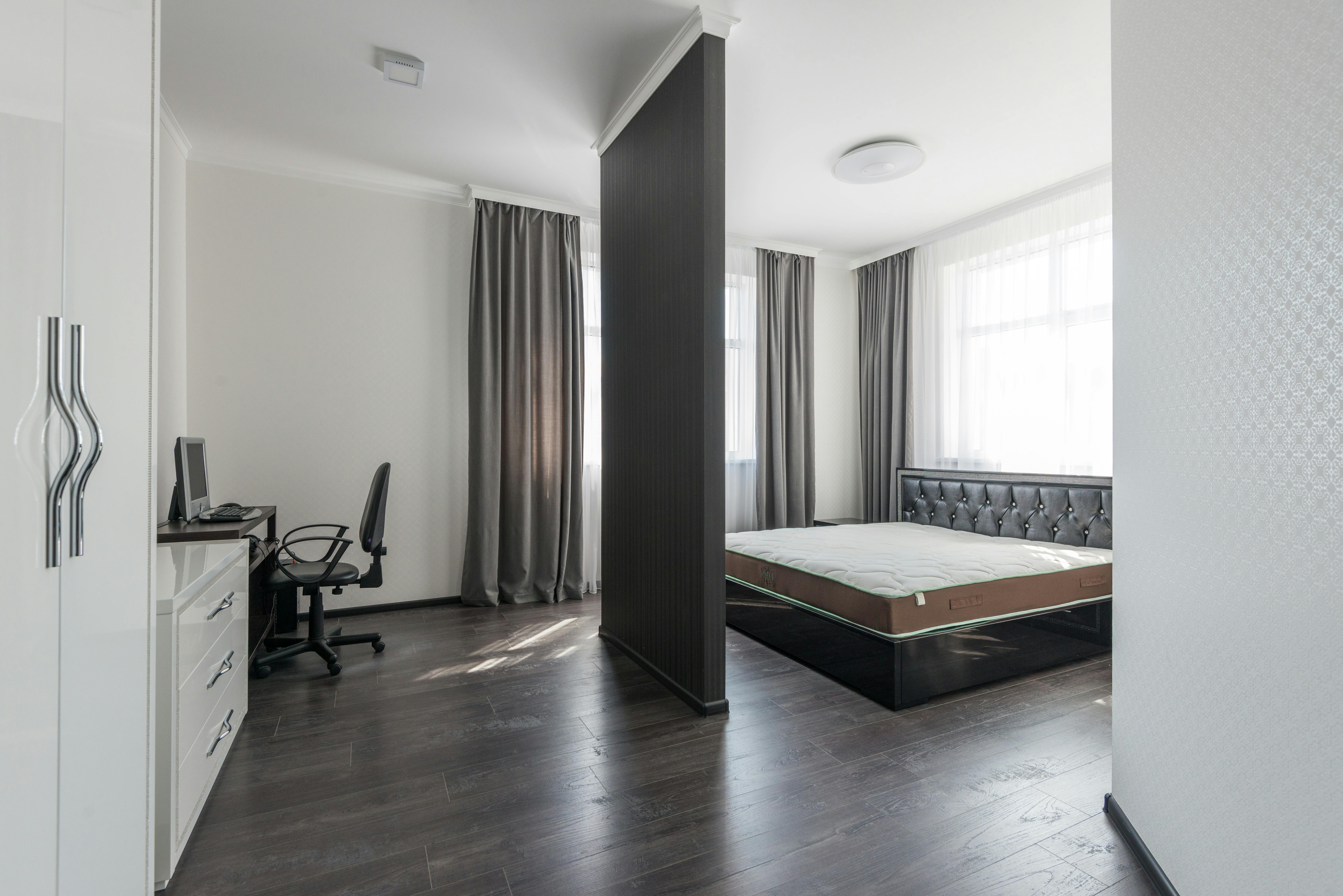 Spacious modern bedroom interior with a minimalist design and home office area.