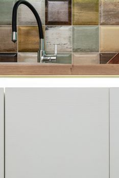 Kitchen sink against multicolored square tiles