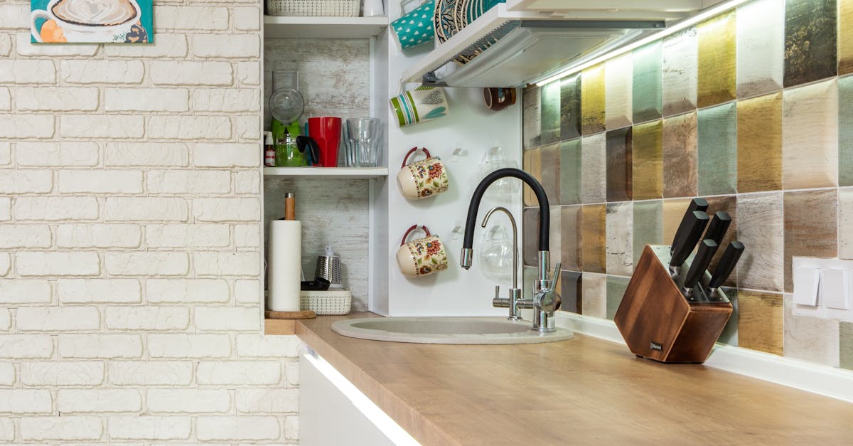 Stylish kitchen counter with various dishware on shelves near sink ...