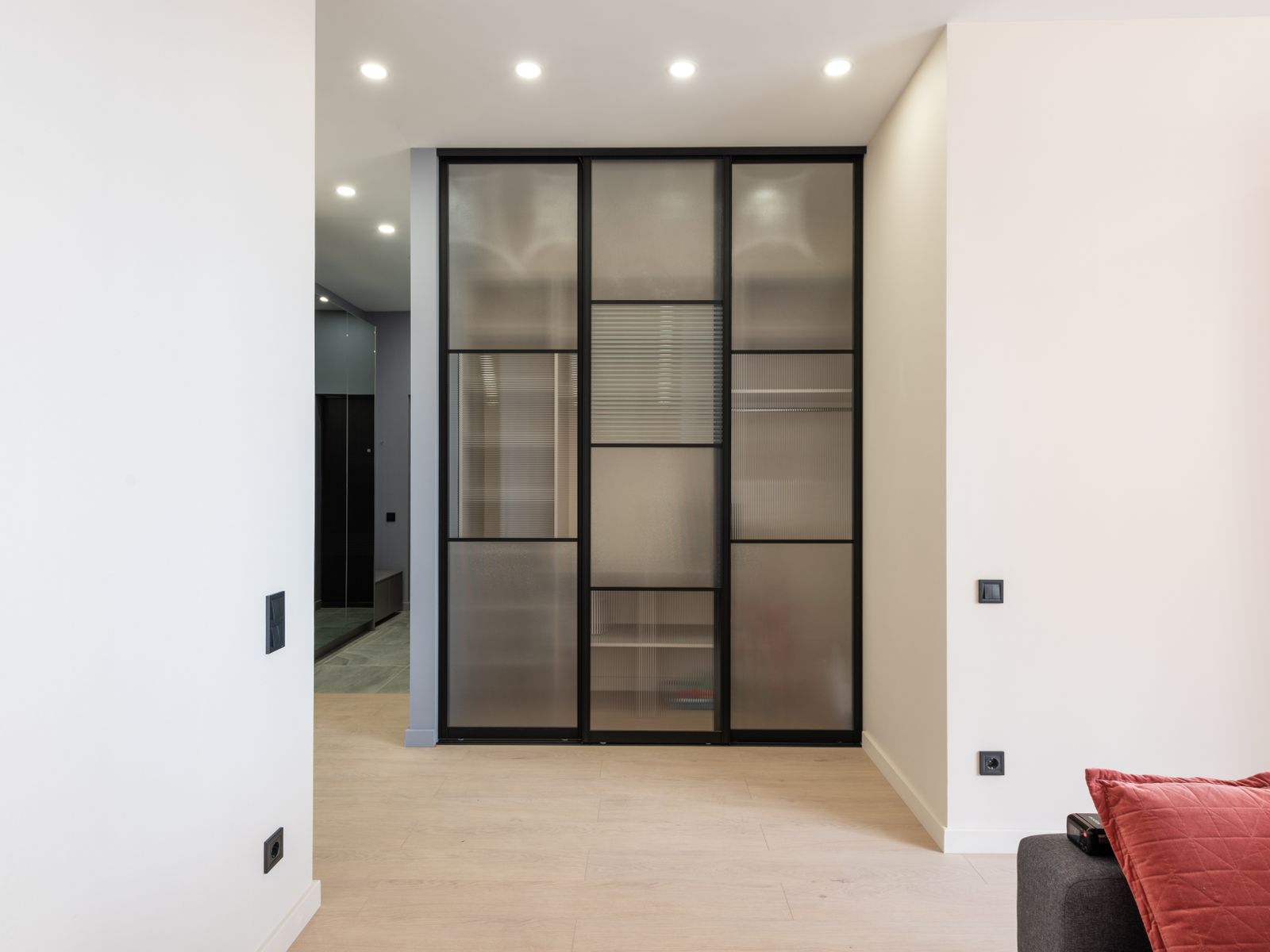 Aluminium framed swing shutter with glass infill on a dark cabinet