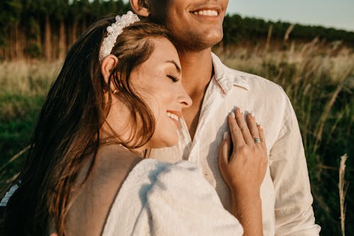 Happy girlfriend leaning on shoulder of boyfriend