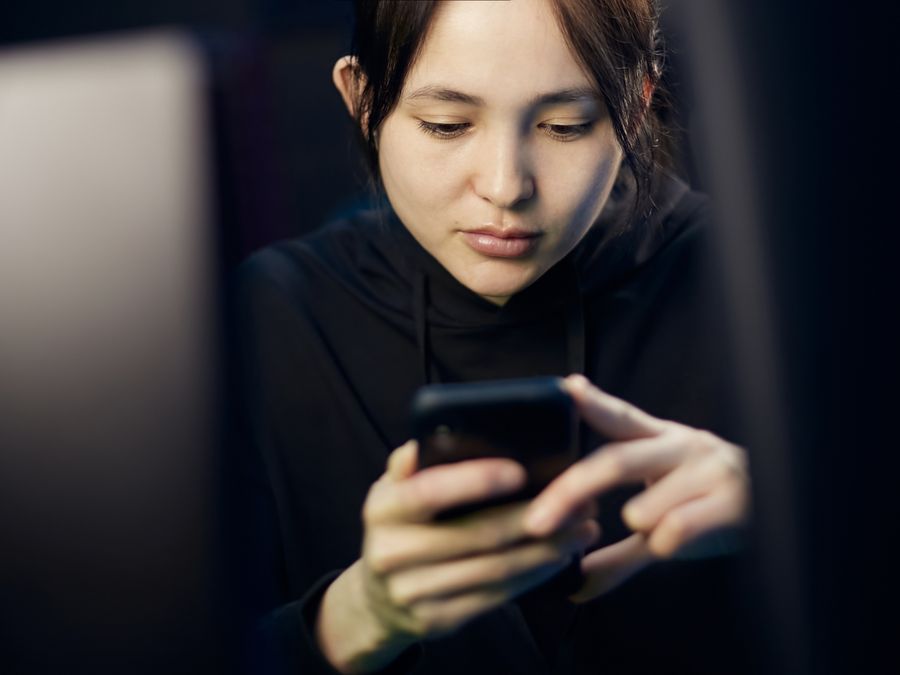 A person studying content on a smartphone screen with focus