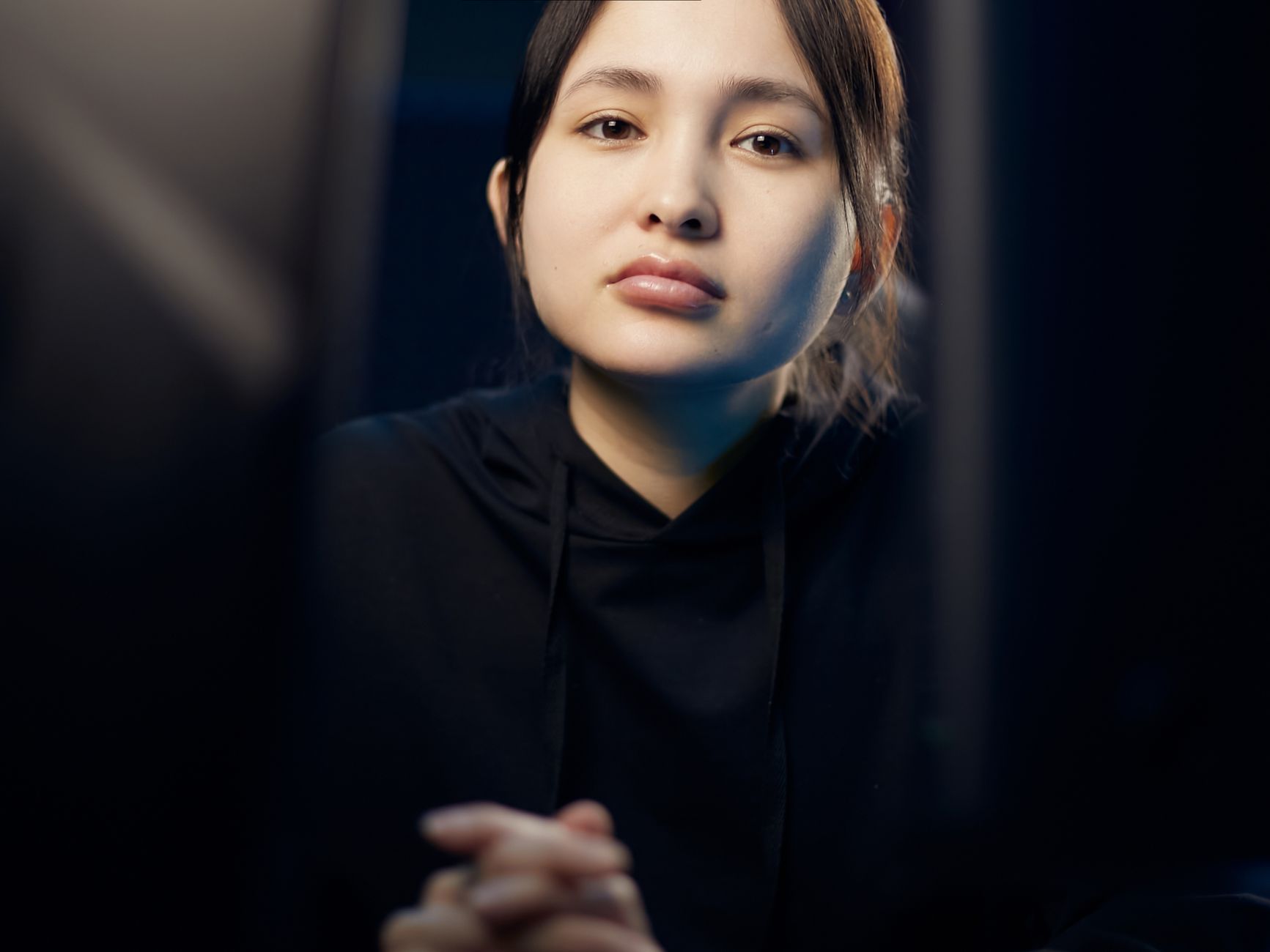 어두운 방에서 라이선스 정보가 표시된 온라인 카지노 웹사이트를 신중하게 확인하는 스마트폰 화면