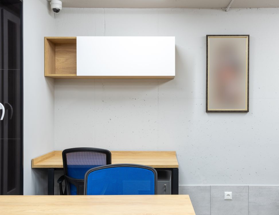 Office desks, chairs and shelving in a furnished workspace