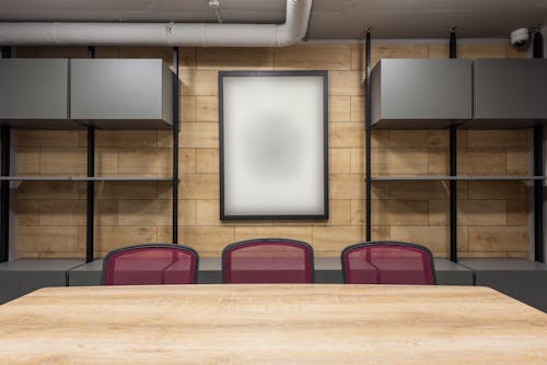 Contemporary interior of new boardroom equipped with wooden table and red office chairs