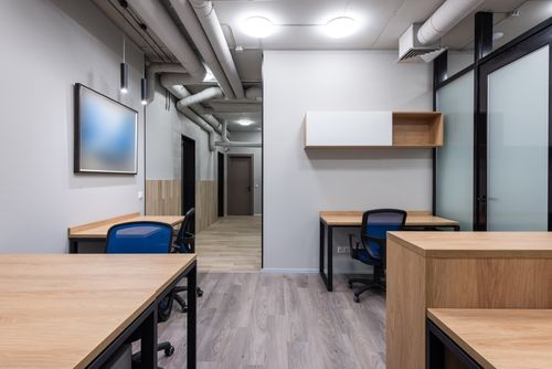 Desk bay with wooden furniture and task chair — photo by Max Vakhtbovych on Pexels