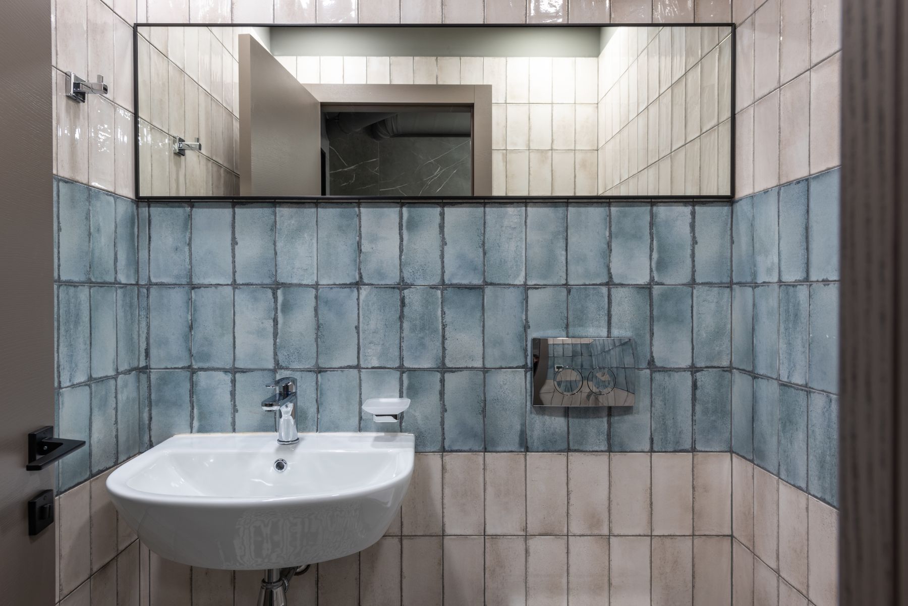 Blue-and-white wall beside a frequently used ceramic sink