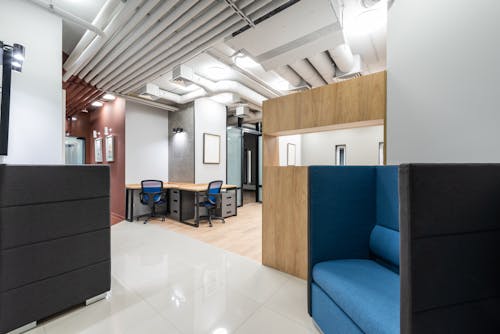 Interior of new spacious office equipped with contemporary furniture including tables and chairs and armchairs