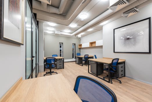 Contemporary office interior with desks, chairs, and abstract art. Ideal for business settings.