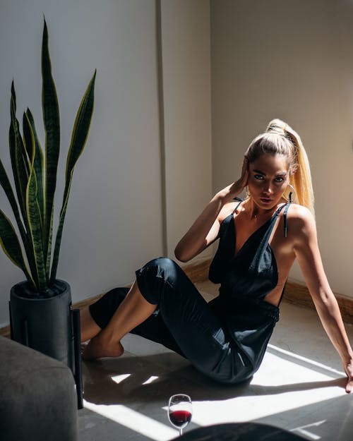 Woman Posing While Sitting on the Floor with a Glass of Red Wine 