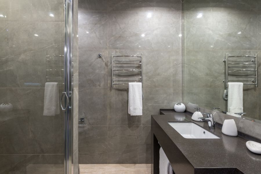 Anthracite-tiled walk-in shower with a clear glass screen