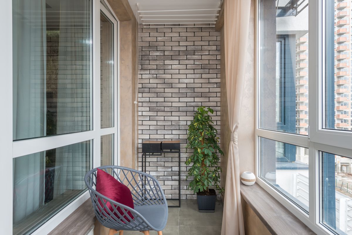 Contemporary apartment balcony with compact chair and potted plant