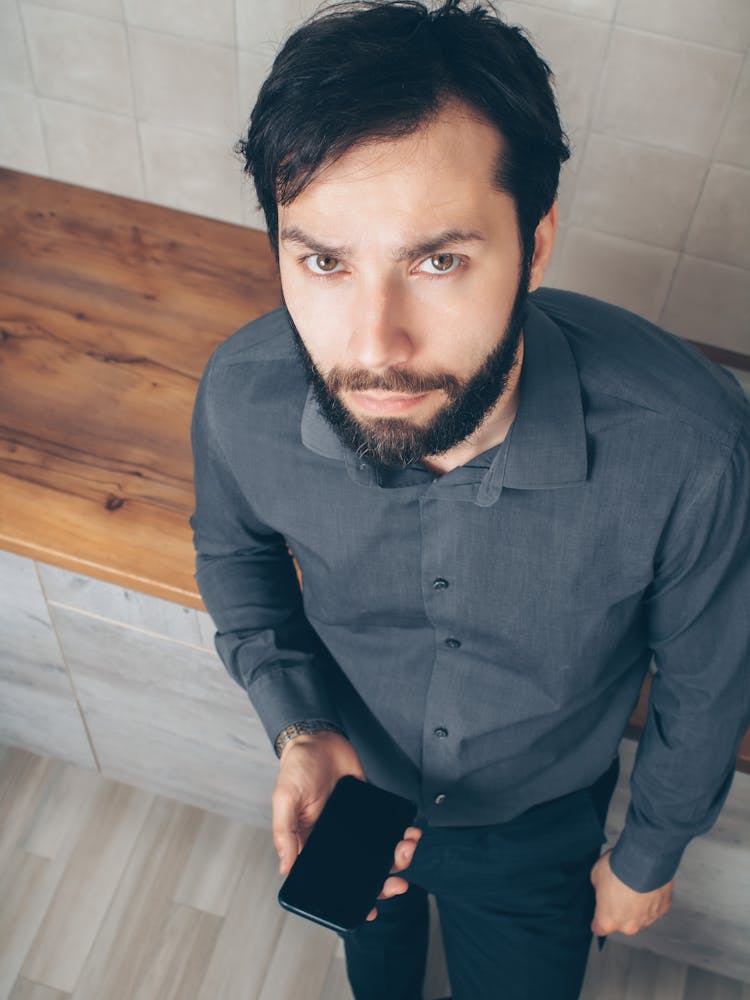 Man In A Dress Shirt Holding A Smartphone